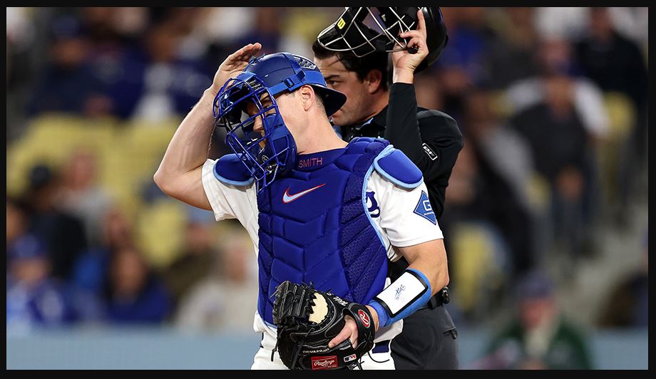A catcher tapping his helmet to initiate an ABS pitch challenge — the 2026 MLB season's most consequential new mechanic.